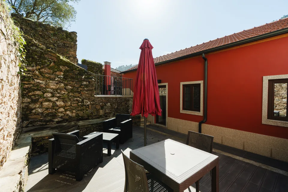 Patio furniture, red facade and stone wall