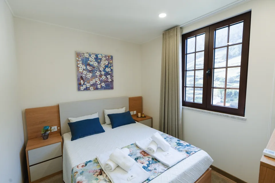 Bedroom 3 double bed beneath artwork beside window