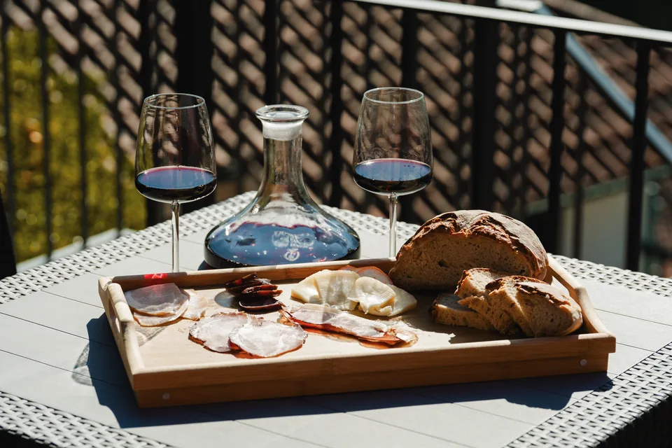 Cheese and charcuterie board, bread, carafe and wine glasses