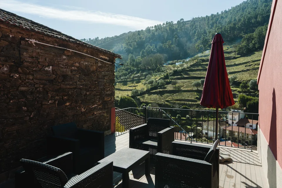 Terrace furniture with closed umbrella and vine terraces beyond